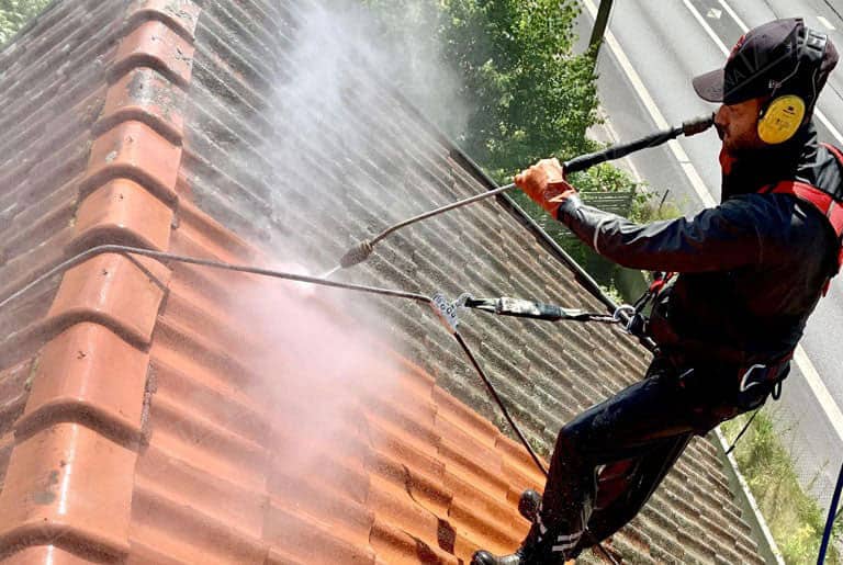 En man från Renatak Syd tvättar taket